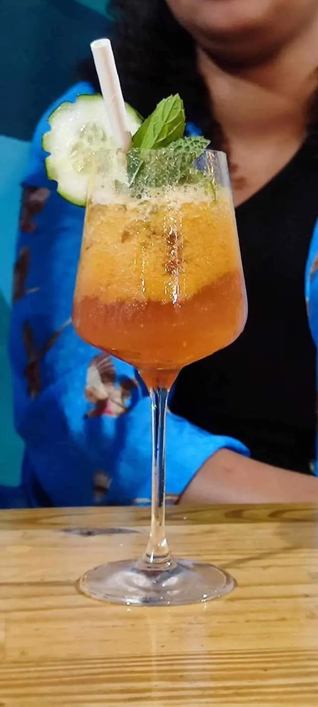 Un cocktail ambré sur fond bleu