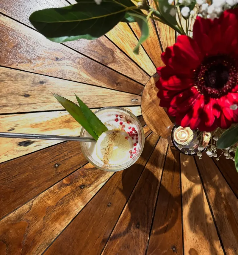 Une table en bois et une fleur rouge