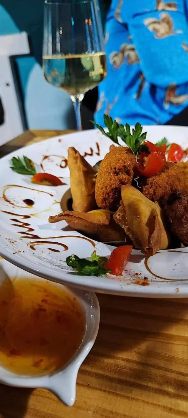 Des samoussas et des bouchons sur une assiette, avec une sauce